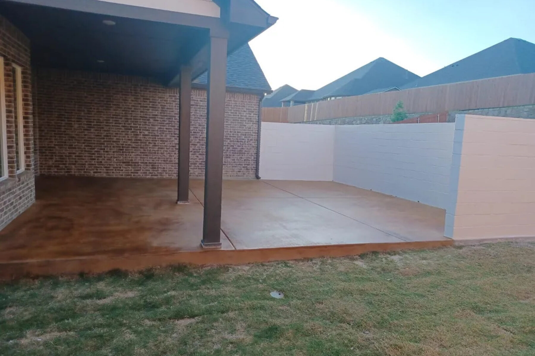 Stained concrete patio under a covered porch, poured by Fast Service Concrete
