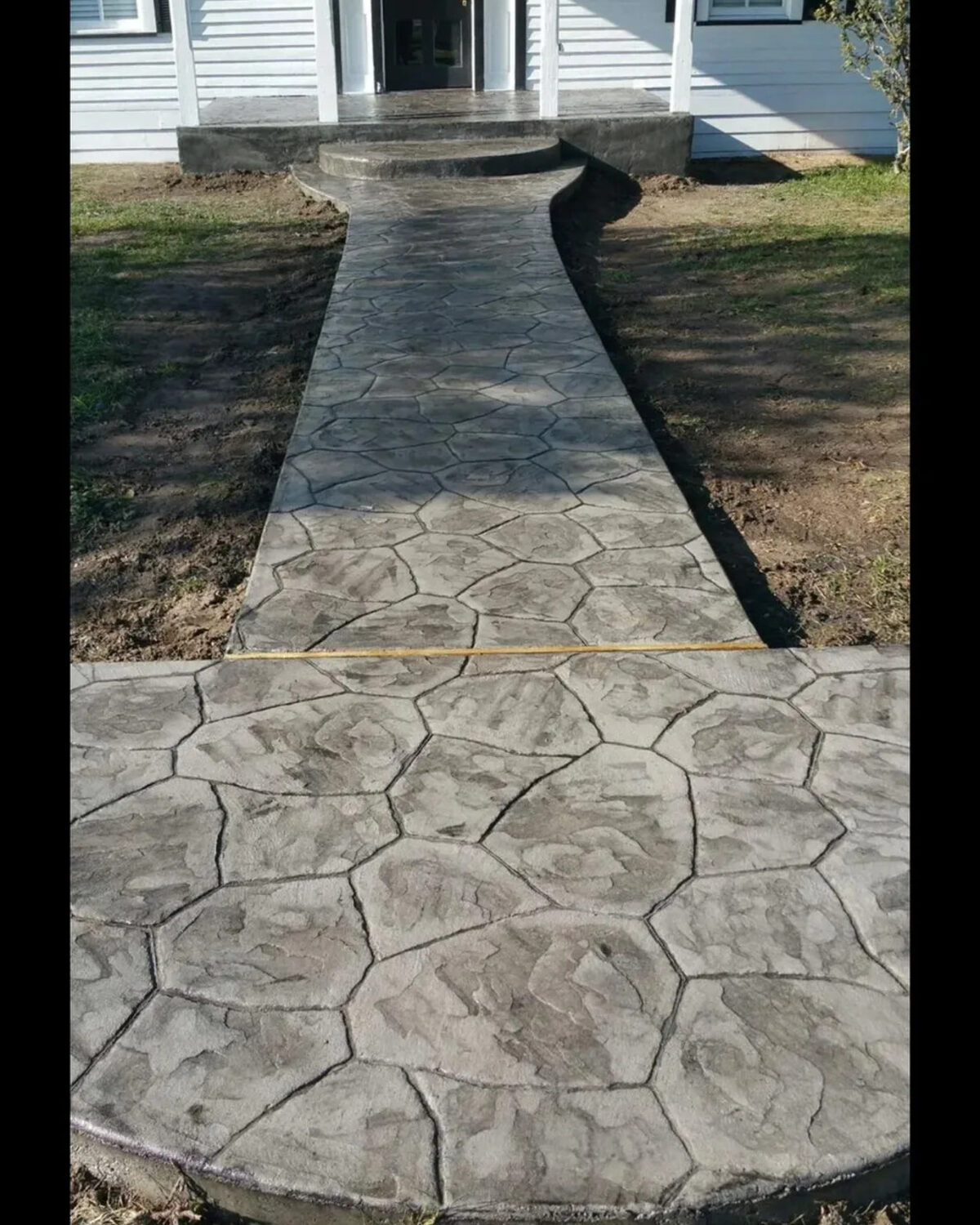 Stamped stone-pattern concrete walkway leading to a front door